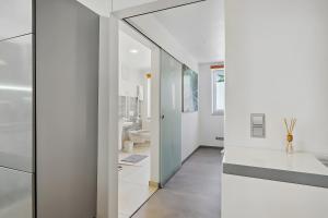 a bathroom with white walls and a sliding glass door at Ferienwohnung "Zum Segel" 2 in Zadelsdorf