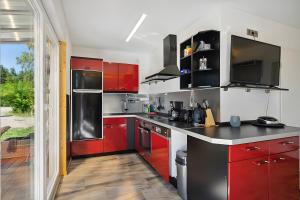 a kitchen with red cabinets and black counter tops at Ferienhaus 110 in Stelzendorf +10 photos