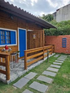 a wooden house with a blue door and a table at Cedro Rosa in Guarapari