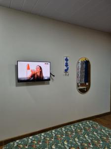 a television on a wall in a bedroom at Cedro Rosa in Guarapari