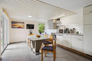 a kitchen with white cabinets and a table and chairs at Ferienhaus 36 in Stelzendorf