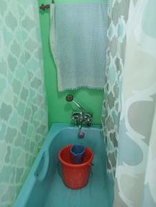 a bathroom with a tub with a bucket in it at Holiday Home in Srinagar