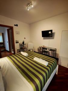 une chambre avec un lit avec une télévision au mur dans l'établissement Leonardo Rome Holidays, à Fiumicino