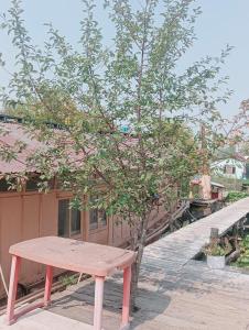 a wooden bench sitting next to a tree on a boardwalk at Holiday Home in Srinagar +22 photos