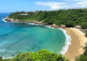 una vista aerea di una spiaggia con persone in acqua di Tribu Tipis & Surf a Puerto Escondido Altre 20 foto