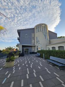 un grande edificio con panchine di fronte ad esso di Mareneve Resort a Linguaglossa
