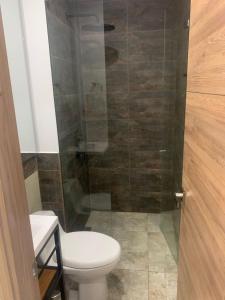 um banheiro com vaso sanitário e box de vidro em Rodadero Cmol945 em Santa Marta