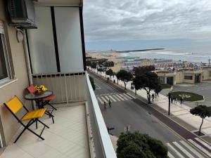 a balcony with a table and chairs and a view of a street at Beach front at Carvalhido in Póvoa de Varzim