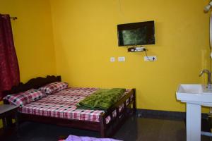 a yellow room with a bed and a sink at Wood stone step in Napoklu