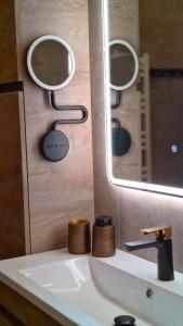 een badkamer met twee spiegels boven een wastafel bij Garden Villa ' Lava Forest ' in Selfoss +65 foto's