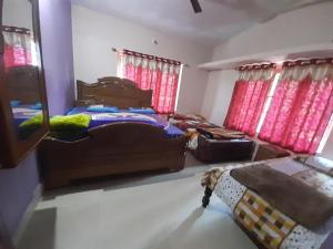 a bedroom with two beds and red curtains at Wood stone step in Napoklu +2 photos