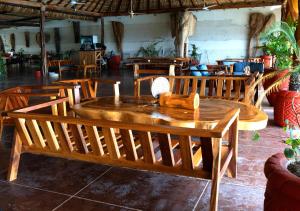 un tavolo e sedie in legno presso il ristorante di Tribu Tipis & Surf a Puerto Escondido