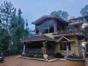 a large yellow house with a balcony at Wood stone step in Napoklu