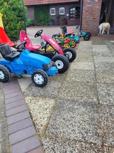 a row of four toy vehicles parked in a yard at Ferienhaus Landskron in Wangerland