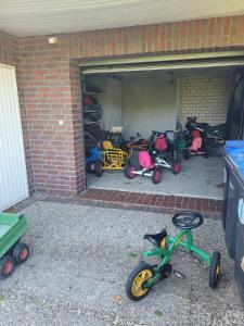 a group of childrens bikes and strollers in a garage at Ferienhaus Landskron in Wangerland +26 photos