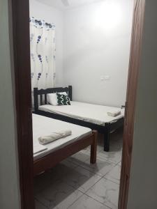 a small room with two beds and a mirror at Blessing homes in Mombasa
