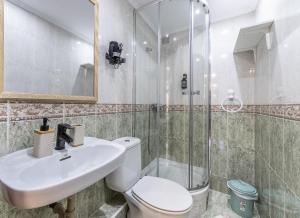 a bathroom with a toilet and a sink and a shower at EMAROOMS Laredo in Laredo +61 photos