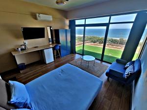 DensainagarにあるWAVES Beach hotel King Shakaの青いソファと大きな窓のあるリビングルーム