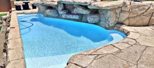 DensainagarにあるWAVES Beach hotel King Shakaの岩壁にある大きな青いプール