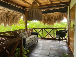 a porch of a house with a couch and a chair at Pirita Beach House in Santa Ana
