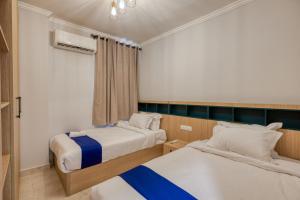 a bedroom with two beds and a window at Travelholic Residence Near Mivida in Cairo