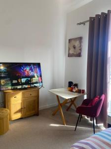a living room with a tv and a table and a chair at Foundry place Rotherham, Sheffield in Rotherham