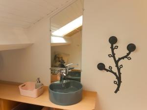 迈松拉菲特Joli duplex refait à neuf, face gare, près Ermitage的带蓝色水槽和镜子的浴室 更多4张照片