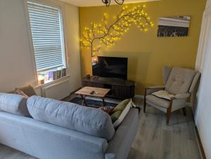 a living room with a blue couch and a tv at Harbour Street Nook in Whitstable