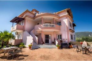 uma casa com cadeiras e mesas em frente em Mirimar - Zante em Alikanas