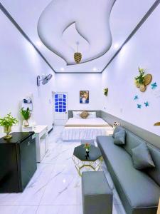 a bedroom with a bed and a couch in a room at Hoàng Nga 1 Homestay in Phan Thiet