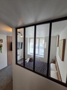 a view of a room with a bedroom through a window at Sweet Cocon Studio in Étampes-sur-Marne +1 photo