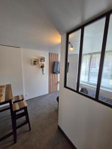 a living room with a table and a window at Sweet Cocon Studio in Étampes-sur-Marne