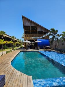 uma piscina num resort com um edifício em Pousada Encantos do Coqueiro em Luis Correia