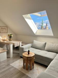 ein Wohnzimmer mit einer Couch und einem Fenster in der Unterkunft Messe Apartment Maisonette - City Center Hannover in Hannover