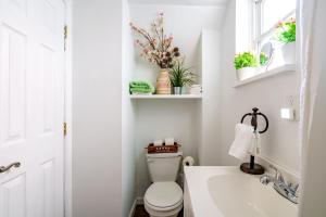 a white bathroom with a toilet and a sink at Jungle House Columbus Downtown Free Parking Sleeps 6 - Steps to Convention Center & Nationwide Arena - 1BR Short North Luxury Home - Over 5,800 Five Star Stays in Columbus