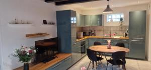 a kitchen with a wooden table and chairs in it at Bleautiful "Aliénor" Charmant appartement avec terrasse in Fontainebleau