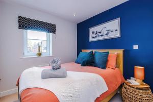 a bedroom with an orange bed with blue walls at 2 bed, 2 bath apartment in Roundhay in Moortown