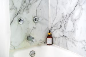 a bottle of wine sits on the edge of a bathroom tub at Short North Convention Private Parking Pets! in Columbus