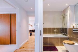 a bathroom with a toilet and a bath tub at 2 bed, 2 bath apartment in Roundhay in Moortown +28 photos