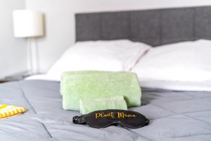 a bed with a green towel and a black sign on it at Short North Convention Private Parking Pets! in Columbus