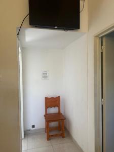 een stoel in een kamer met een televisie aan de muur bij departamentos apart quetzal in Villa Carlos Paz