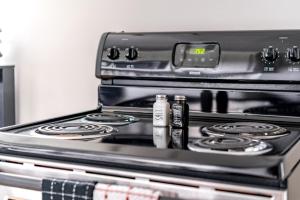 a stove with two bottles sitting on top of it at Jungle House Luxury Stays - Columbus Downtown Short North in Columbus