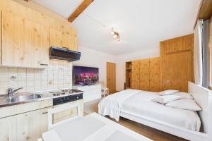 a kitchen with a bed and a sink in a room at Comfortable studio with balcony and panoramic view in Saas-Grund