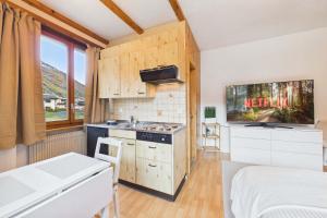 a small kitchen with a sink and a stove at Comfortable studio with balcony and panoramic view in Saas-Grund