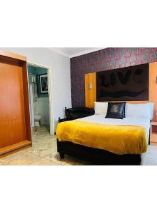 a bedroom with a large bed with a yellow blanket at Lookout Star Legend Accommodation in Parow