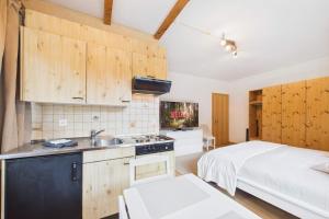 a kitchen with a sink and a bed in a room at Comfortable studio with balcony and panoramic view in Saas-Grund +4 photos