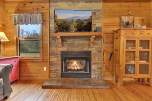 a living room with a fireplace in a log cabin at Creekside Cabin in Cosby +20 photos