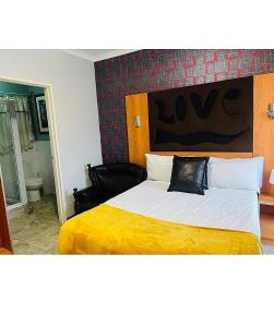 a bedroom with a large bed with a yellow blanket at Lookout Star Legend Accommodation in Parow