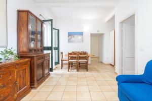 un salon avec une table et un canapé bleu dans l'établissement AffittaSardegna - Domo Pineta, à Santa Lucia