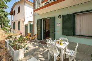 un patio avec une table et des chaises devant une maison dans l'établissement AffittaSardegna - Domo Pineta, à Santa Lucia